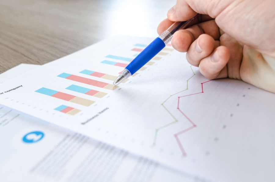 Hand pointing at growth charts on paper