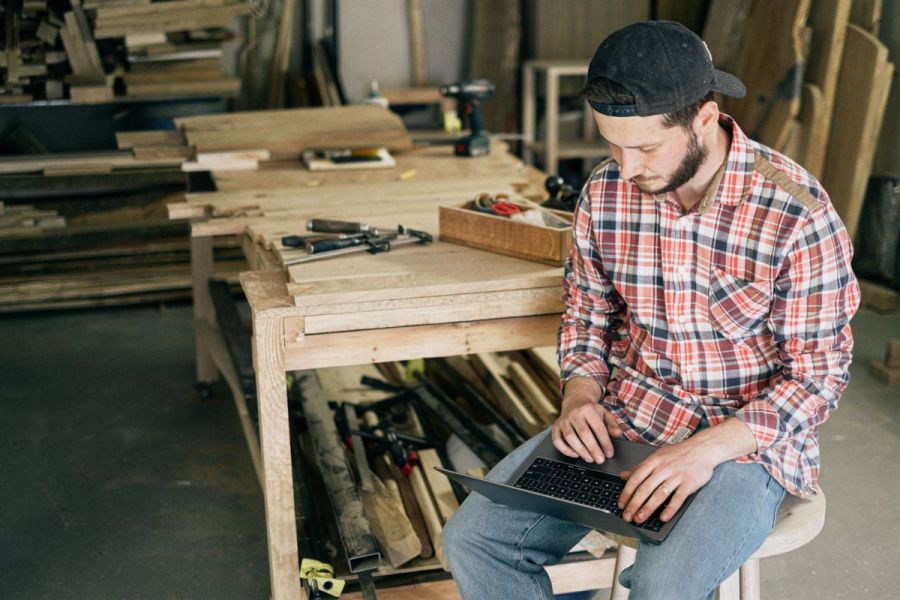 Small business owner working on his website in a workshop